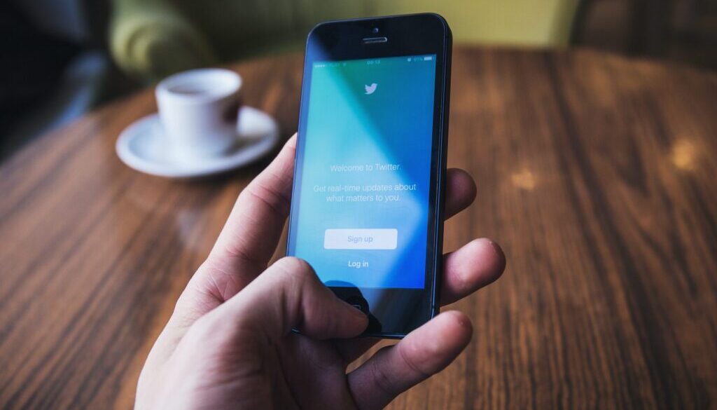 person holding turned on space gray iPhone 5c near table