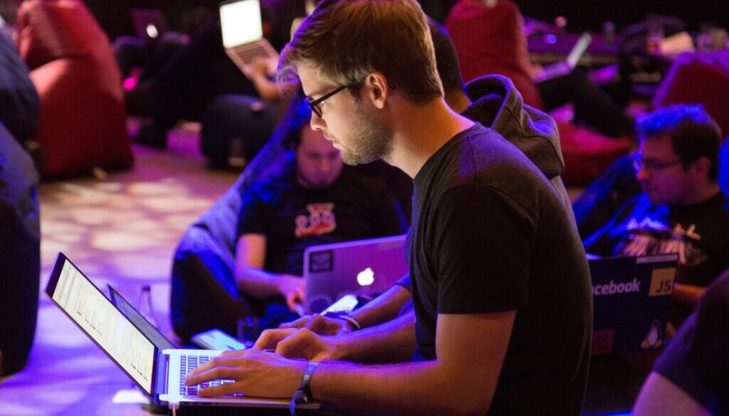 man using laptop in front of brown chair