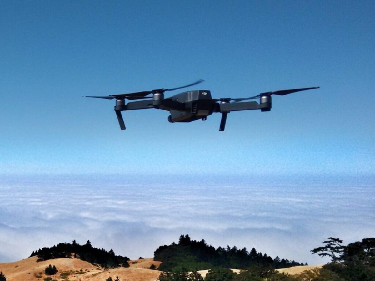 black drone on air over cloudy sky at daytime