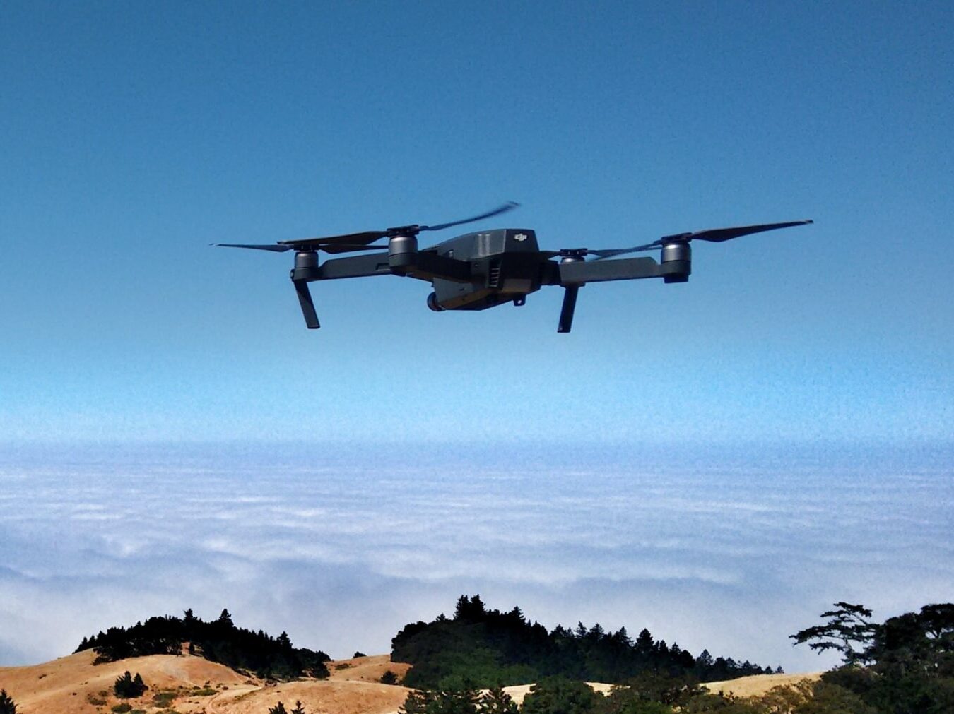 black drone on air over cloudy sky at daytime