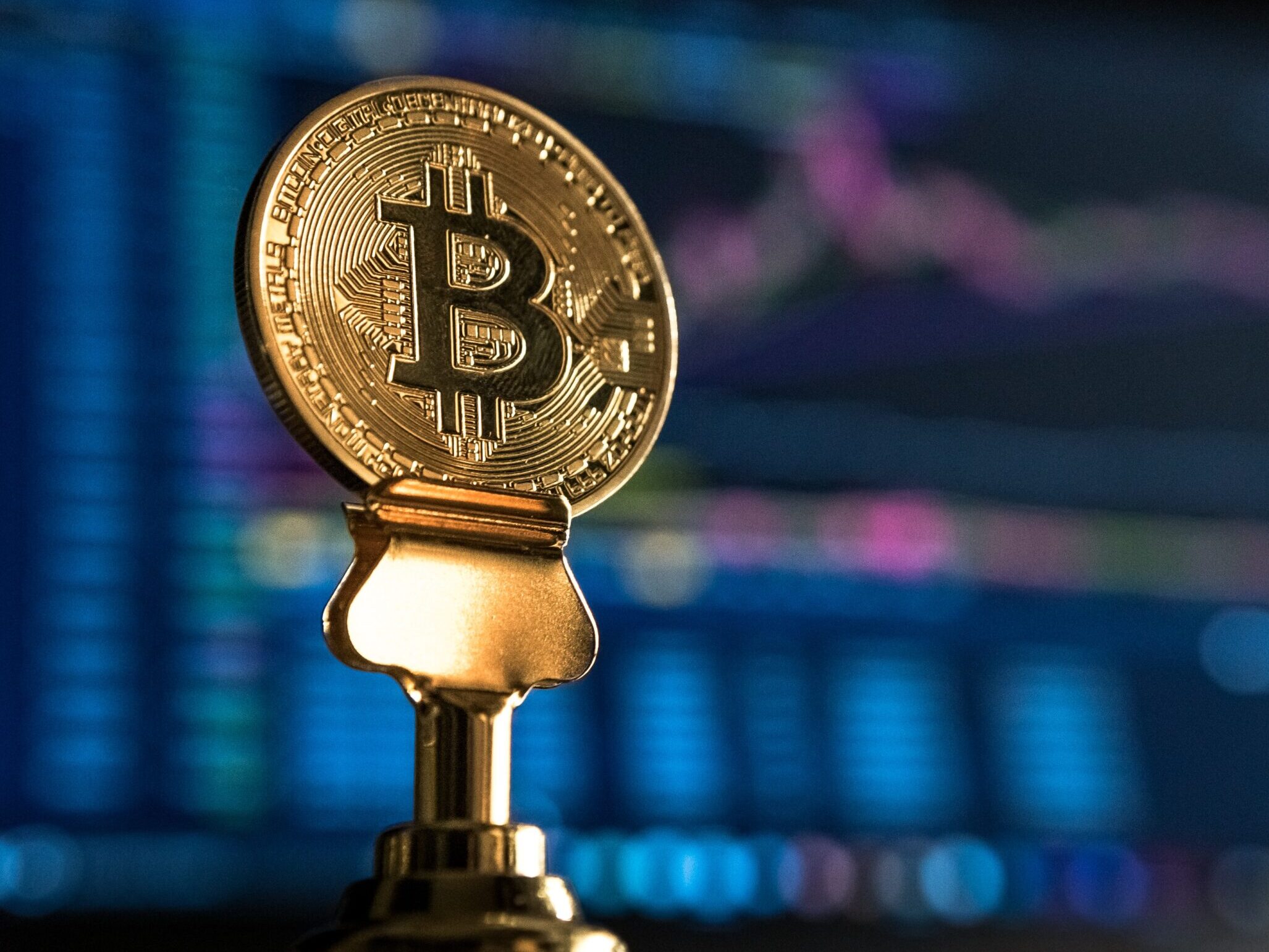 selective focus photo of Bitcoin near monitor
