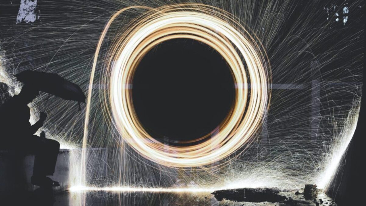 photo of person holding umbrella near steelwool during nighttime