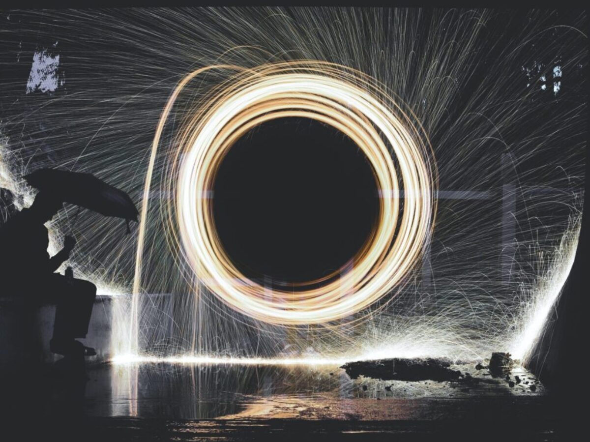 photo of person holding umbrella near steelwool during nighttime