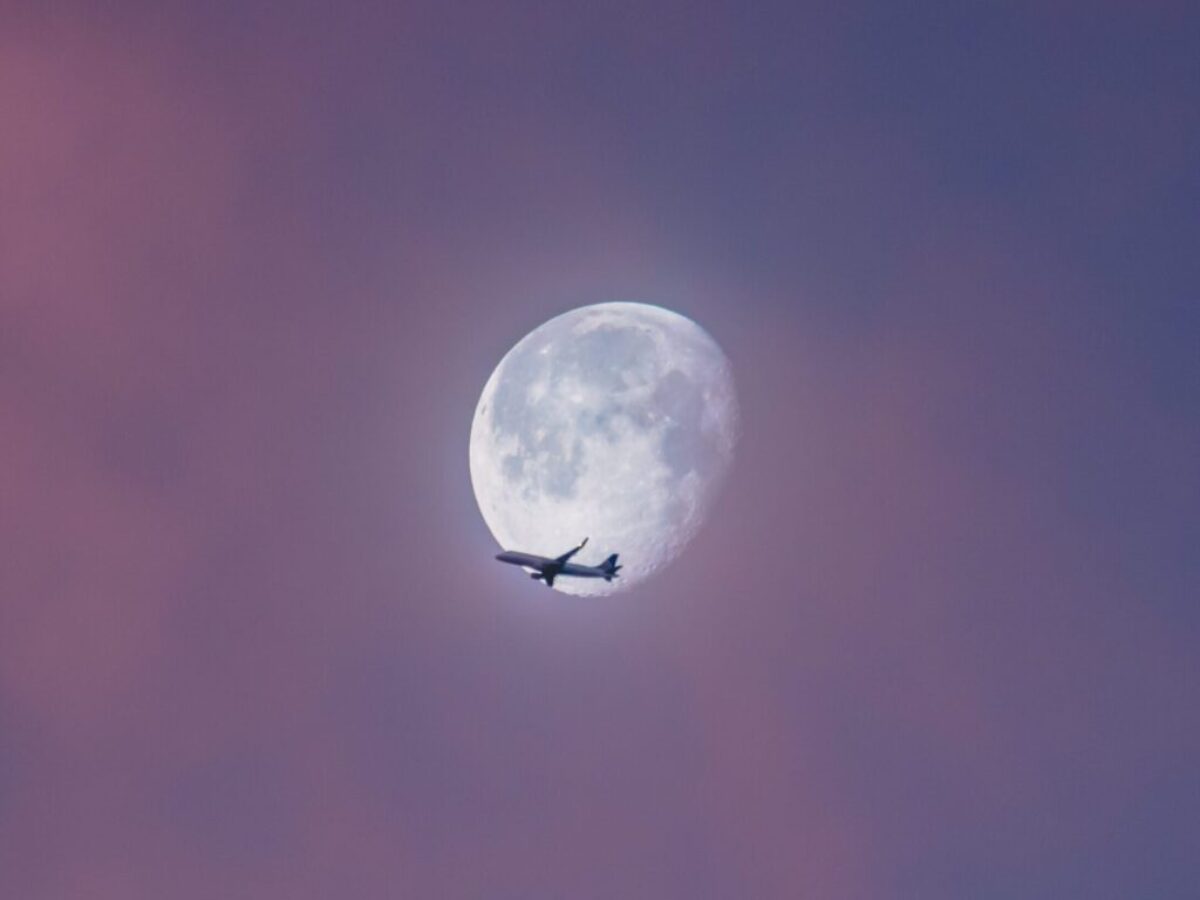 flying plane at sky during full moon at daytime