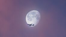 flying plane at sky during full moon at daytime