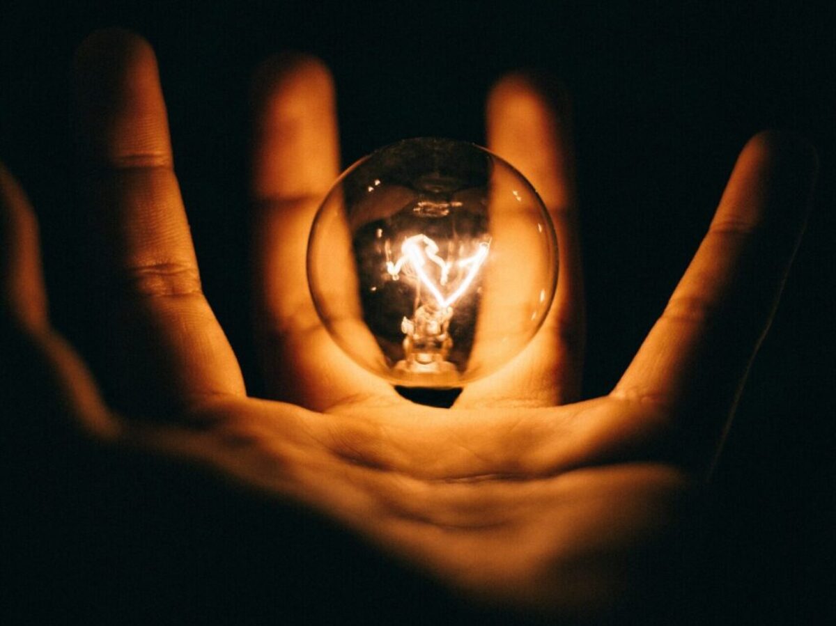 clear glass bulb on human palm