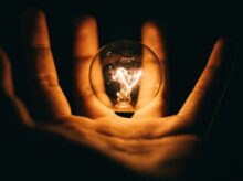 clear glass bulb on human palm