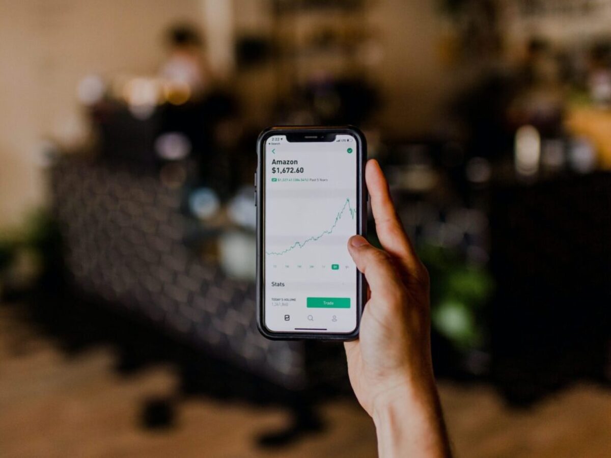 person holding black iPhone displaying stock exchange