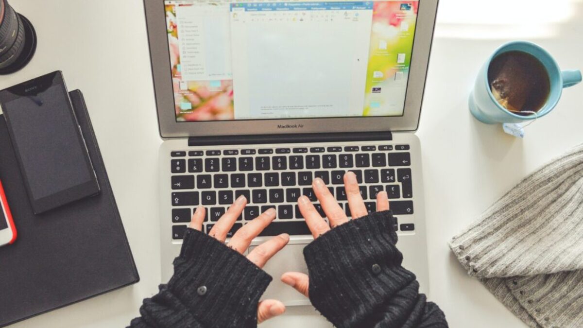 person in black long sleeve shirt using macbook pro