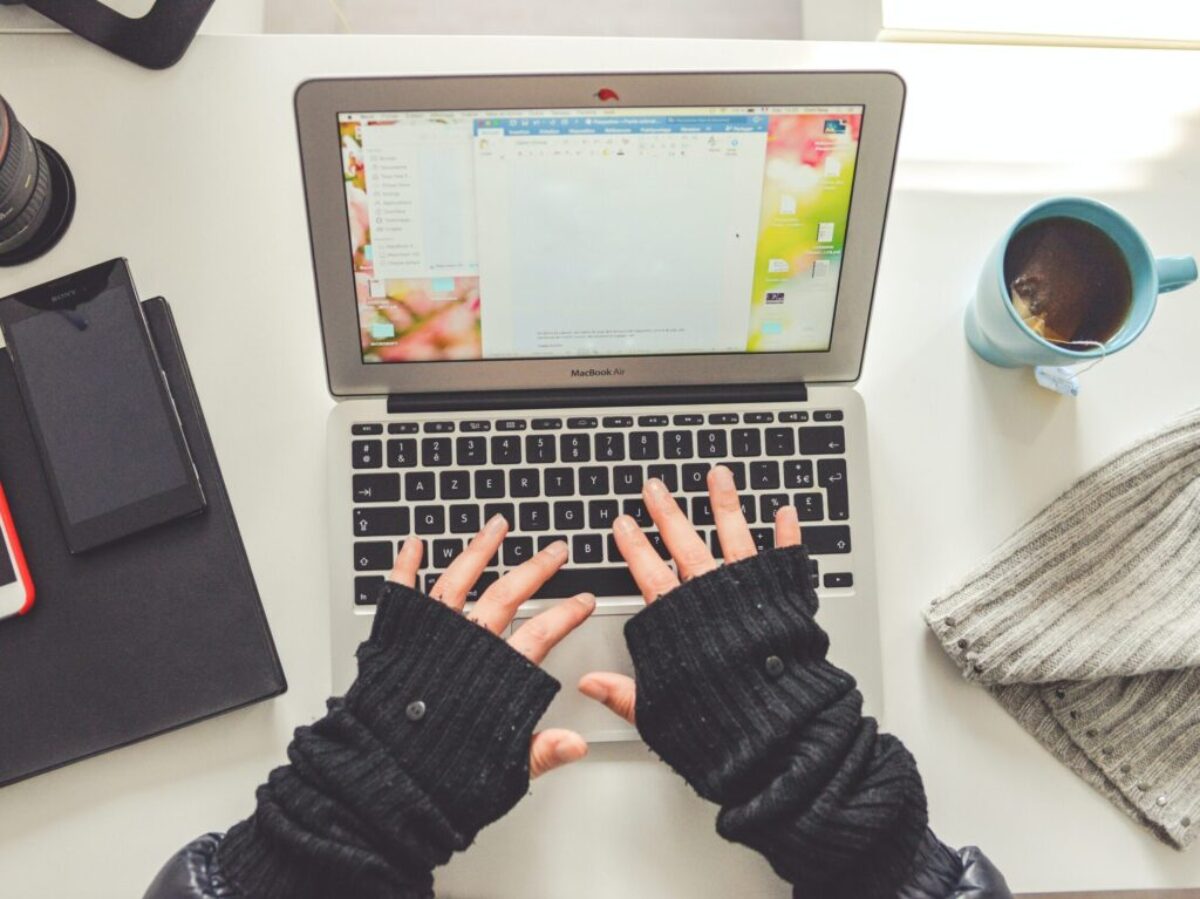 person in black long sleeve shirt using macbook pro