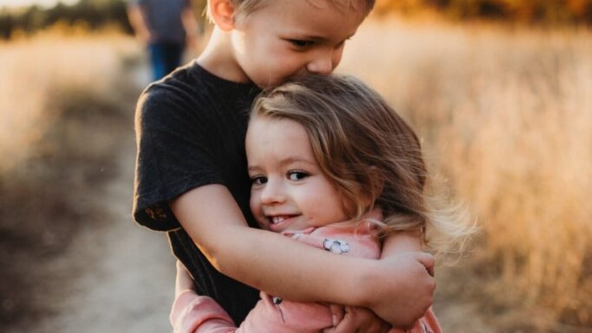 boy in black t-shirt hugging girl in red and white polka dot dress