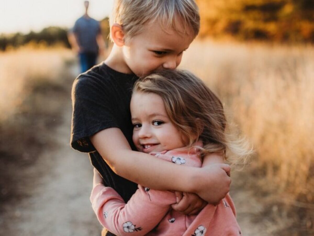 boy in black t-shirt hugging girl in red and white polka dot dress