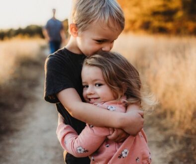 boy in black t-shirt hugging girl in red and white polka dot dress