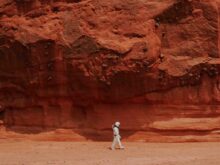 person walking near brown rock