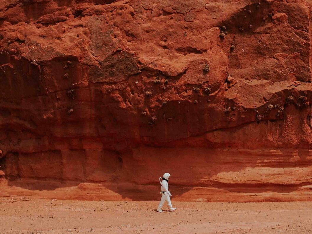 person walking near brown rock