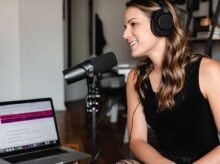 woman in black tank top sitting on chair in front of microphone