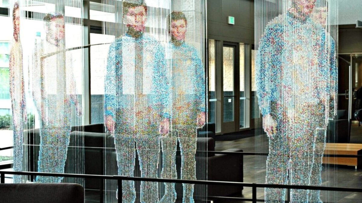 man in white and blue long sleeve shirt standing near glass window