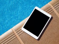 white iPad beside swimming pool