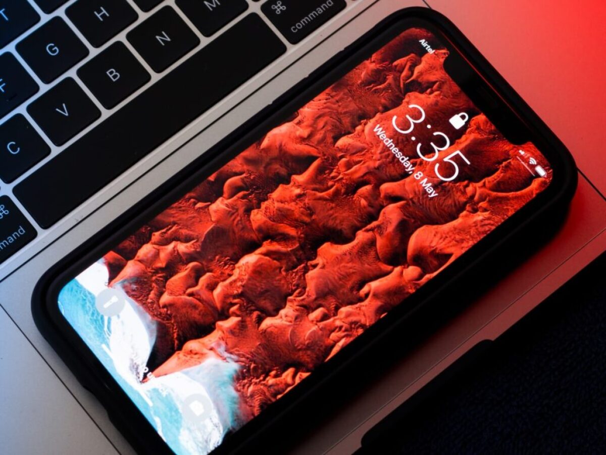 black smartphone on top of MacBook