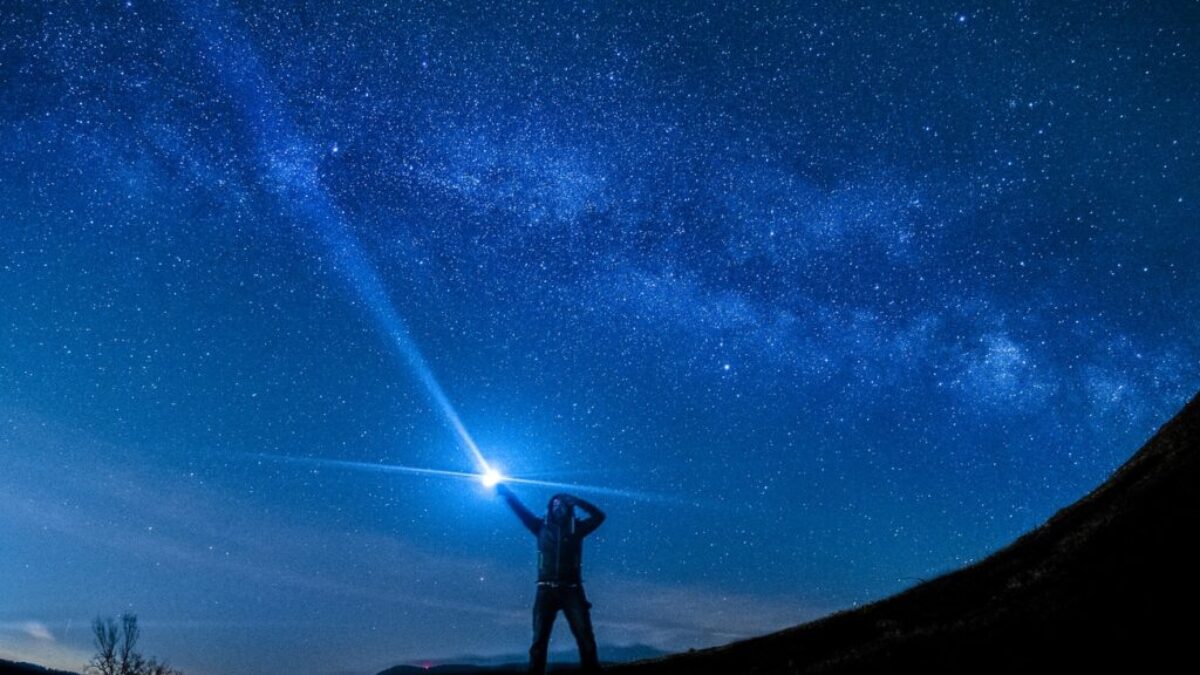 silhouette of man holding flashlight