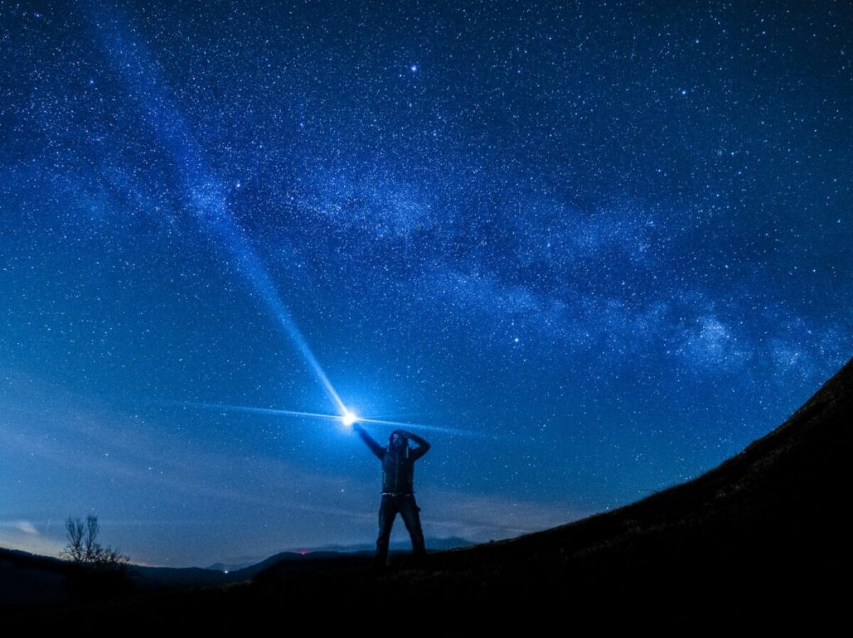 silhouette of man holding flashlight