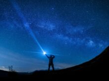 silhouette of man holding flashlight