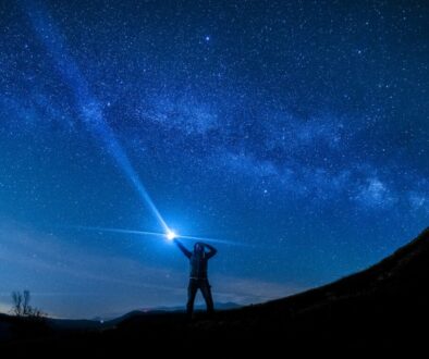 silhouette of man holding flashlight