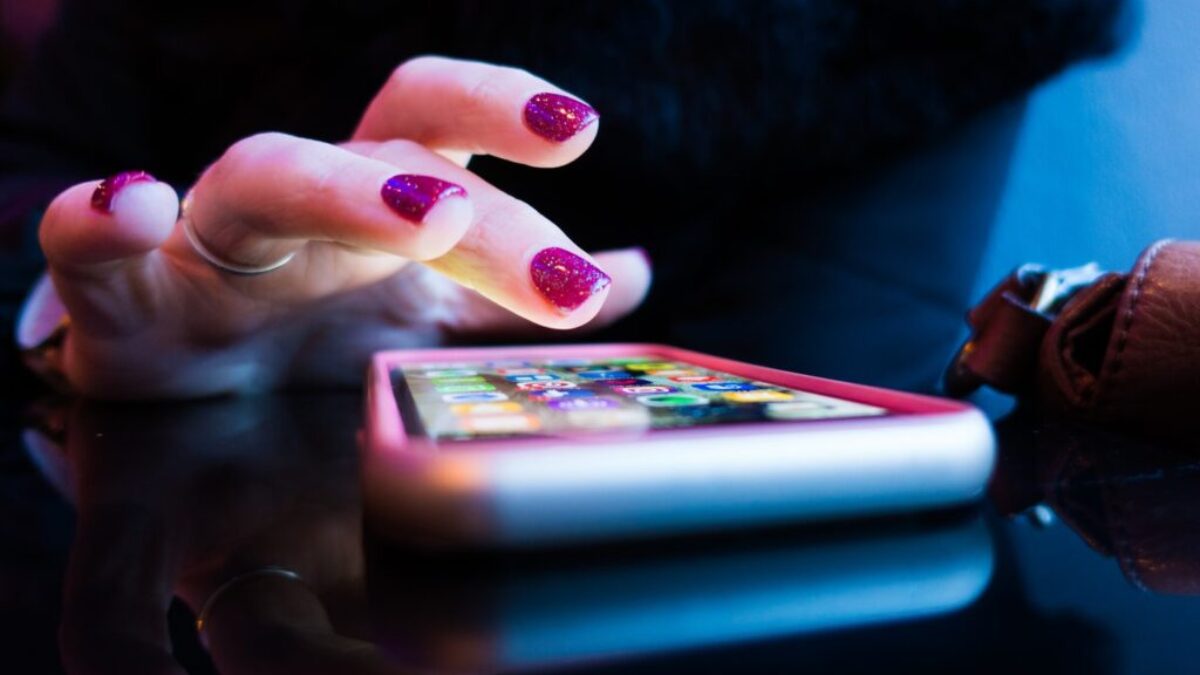person using black smartphone with gray and pink case