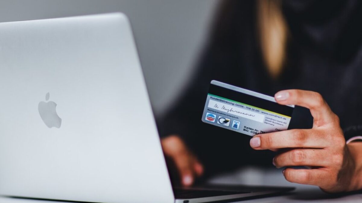 woman holding black smartphone near silver macbook