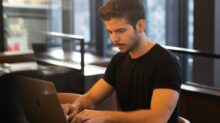 man in black crew neck t-shirt using macbook