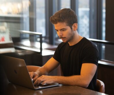 man in black crew neck t-shirt using macbook