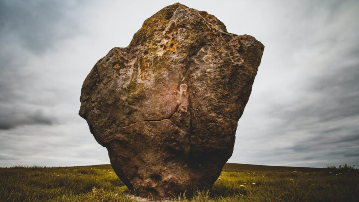 brown rock formation surrounded by green grass