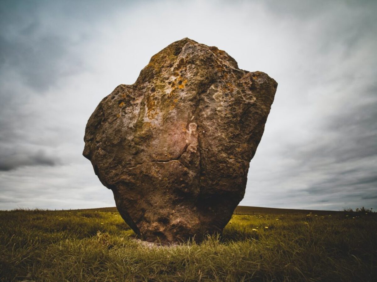 brown rock formation surrounded by green grass