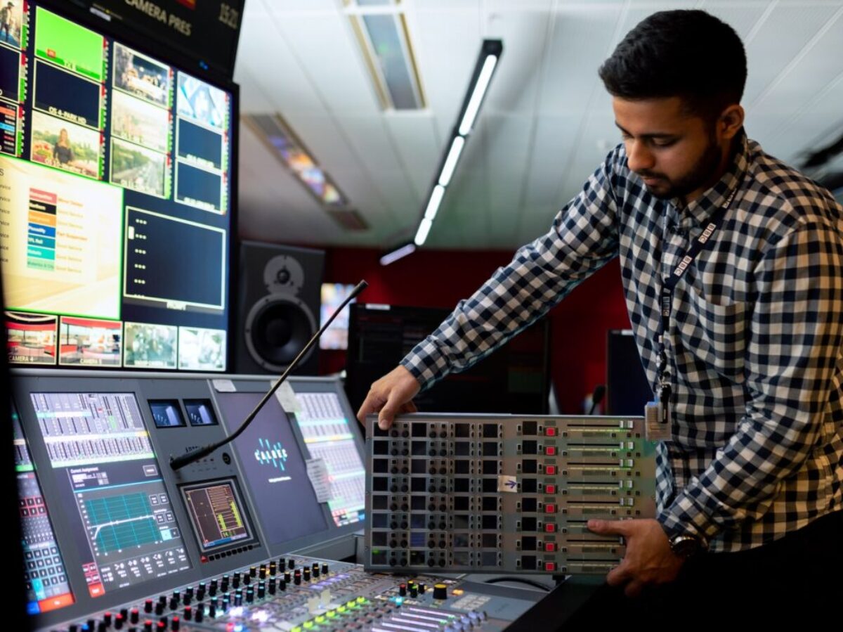 man in black and white checkered dress shirt playing dj controller