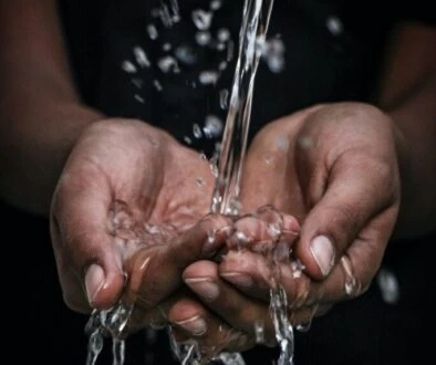 pouring water on person's hands