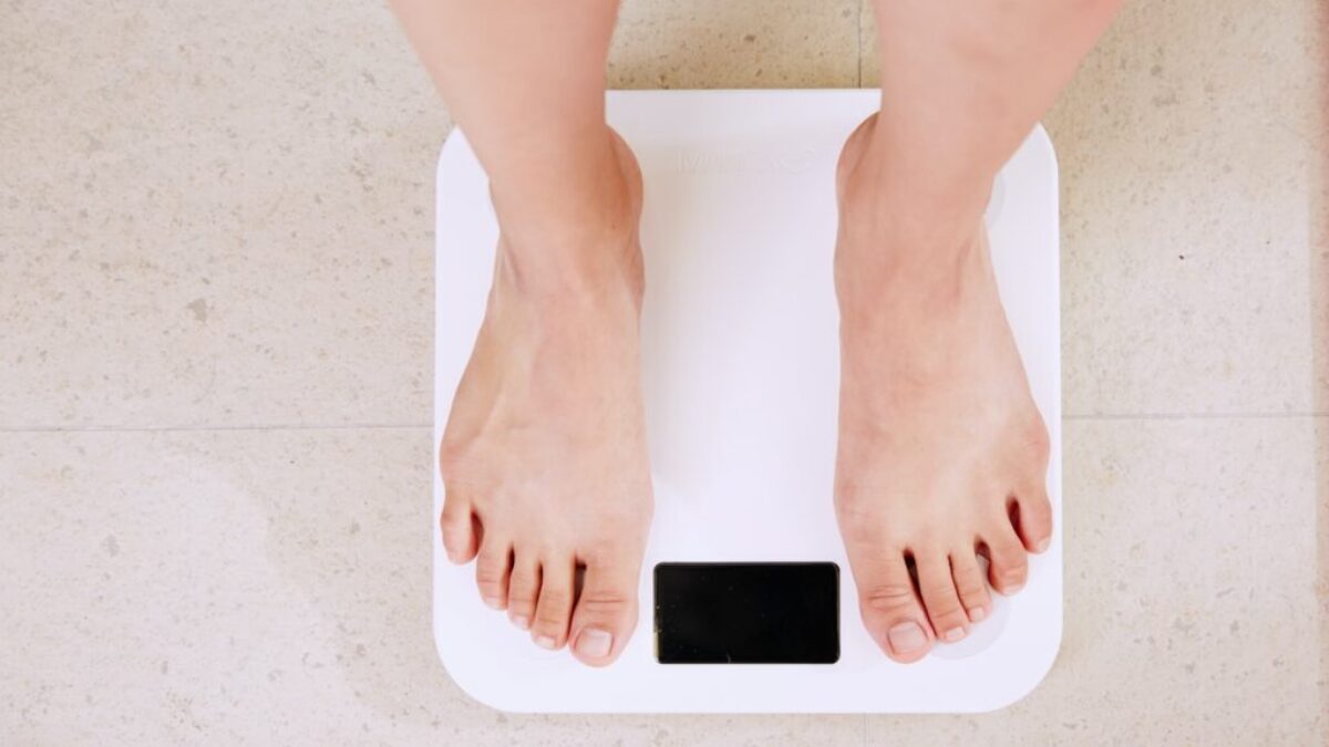 person standing on white digital bathroom scale