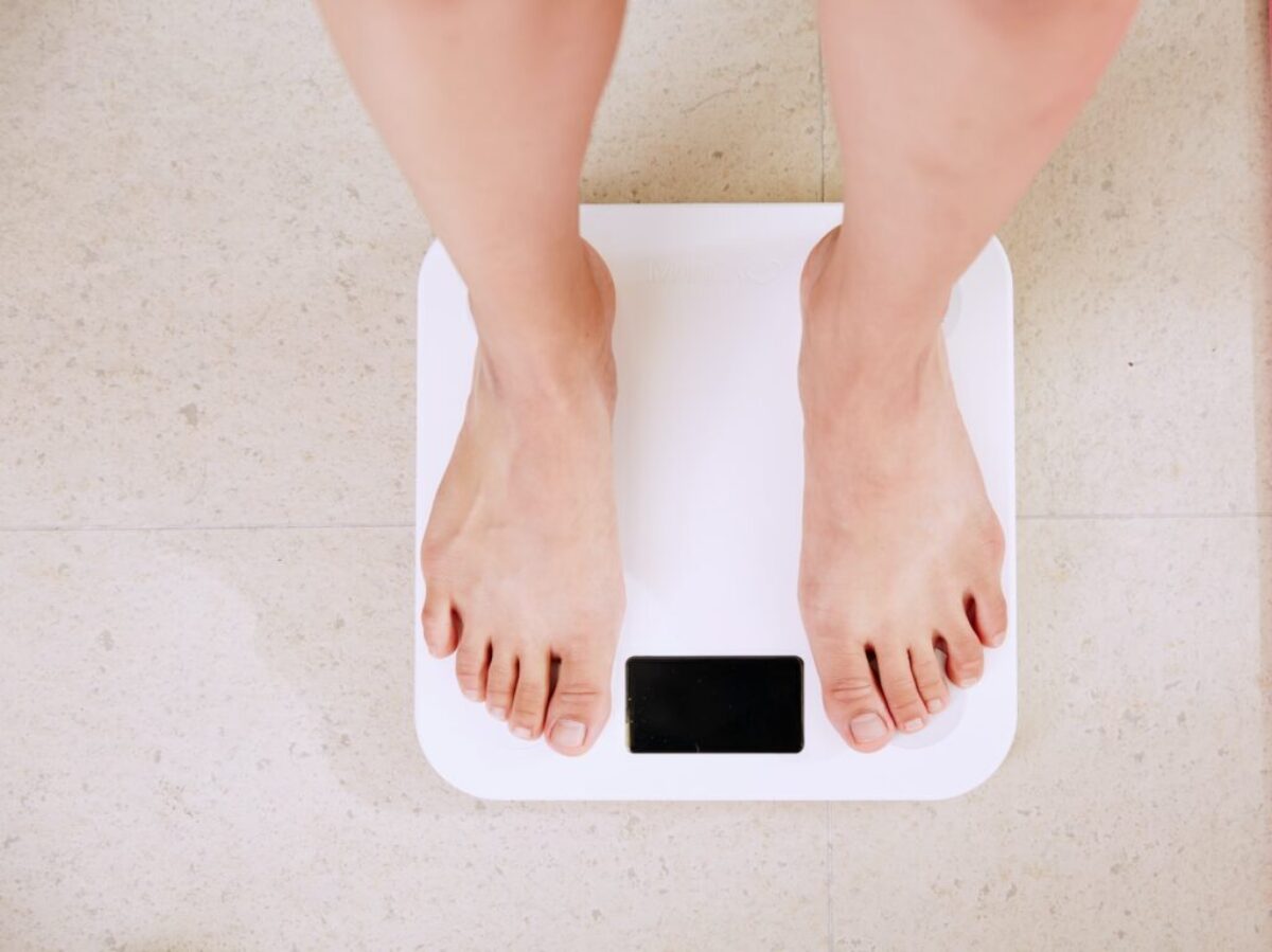 person standing on white digital bathroom scale