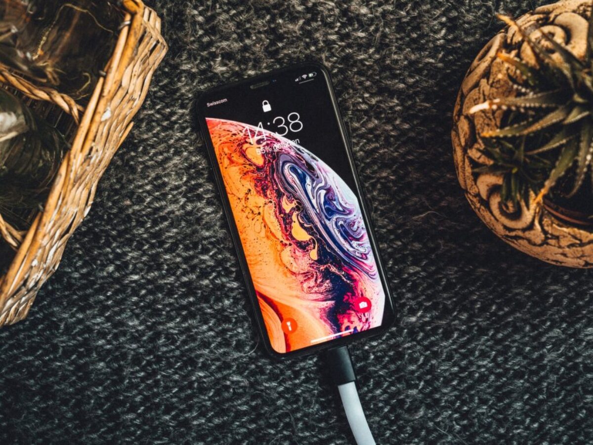 gold iPhone Xs on black textile
