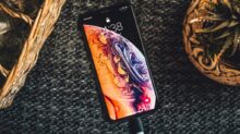 gold iPhone Xs on black textile