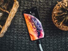 gold iPhone Xs on black textile