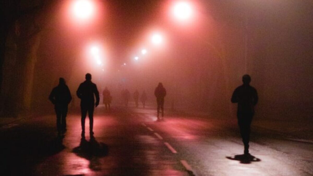 silhouette of people walking on street during night time