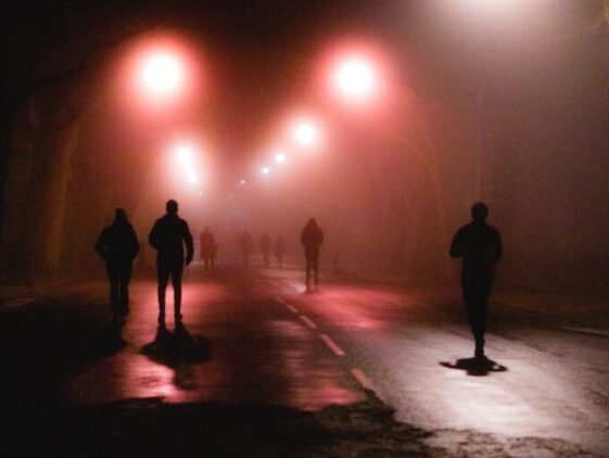 silhouette of people walking on street during night time
