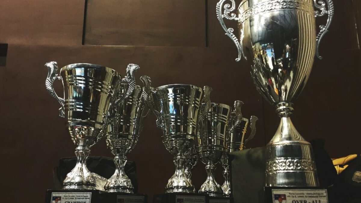 several silver and gold trophies on wooden surface