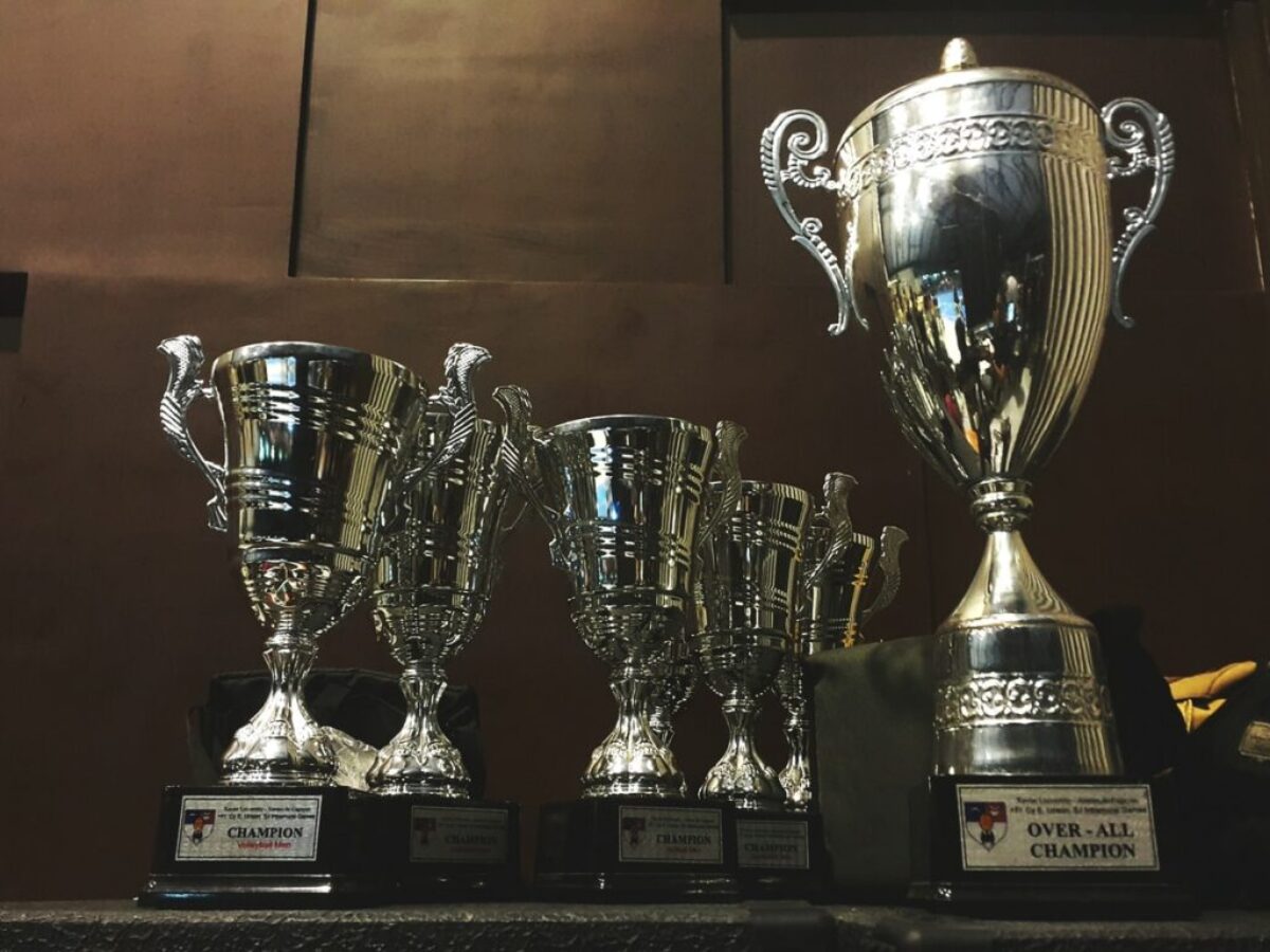 several silver and gold trophies on wooden surface