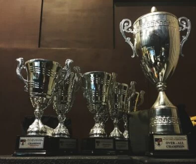 several silver and gold trophies on wooden surface