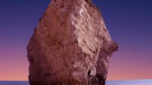brown rock formation with body of water