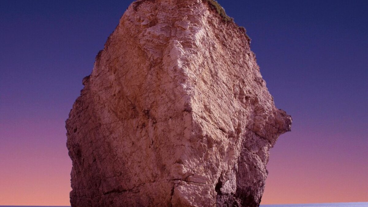 brown rock formation with body of water