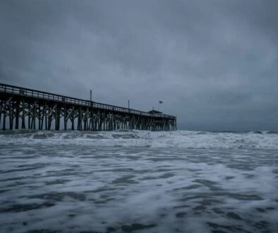 brown wooden dock on sea under white clouds