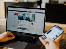 person using both laptop and smartphone