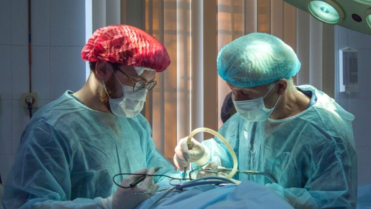 two men wearing blue lab coats